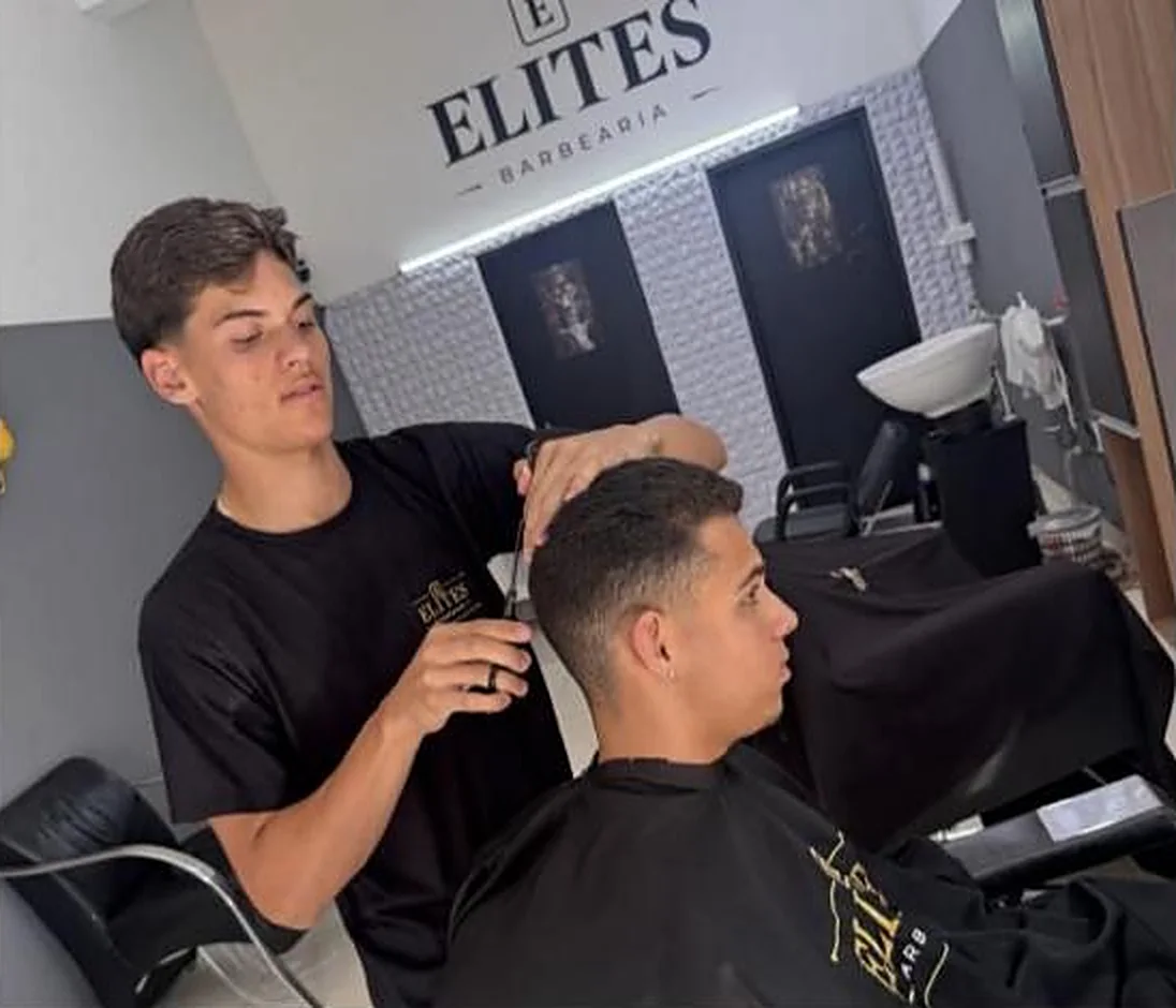 Barbeiro da Elites finalizando um corte com tesoura
